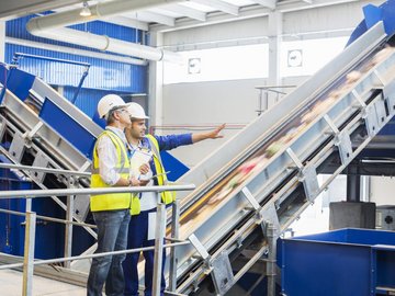 Workers talking in recycling center